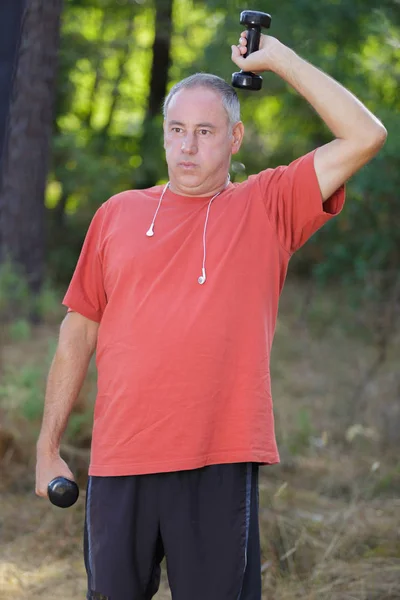 Homme exerçant avec haltère le jour ensoleillé — Photo