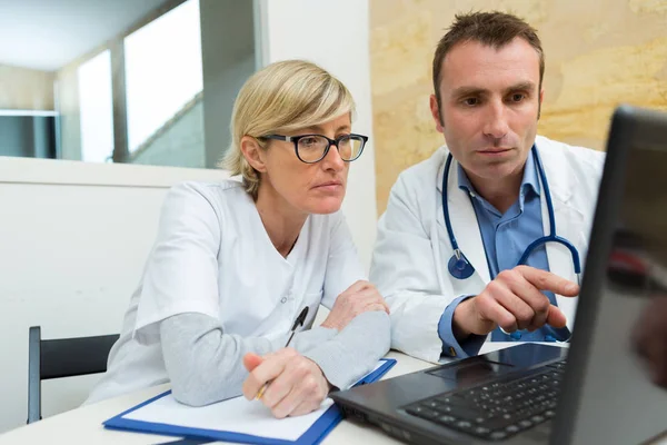 Enfermera y médico mirando la pantalla del ordenador portátil — Foto de Stock