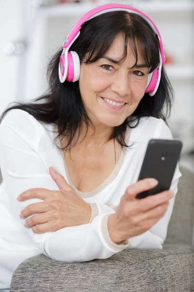 Wanita di rumah mendengarkan musik dengan smartphone — Stok Foto