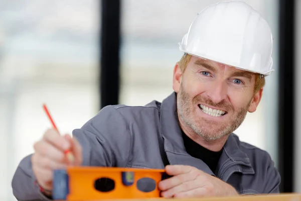 Feliz sorrindo ferramenta construtor segurando — Fotografia de Stock