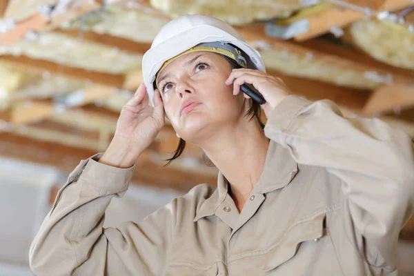 Ingegnere donna con casco di sicurezza parlando al telefono — Foto Stock