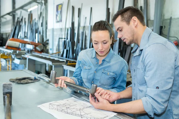 Ingenieros sosteniendo parte de metal y mirando dibujos —  Fotos de Stock