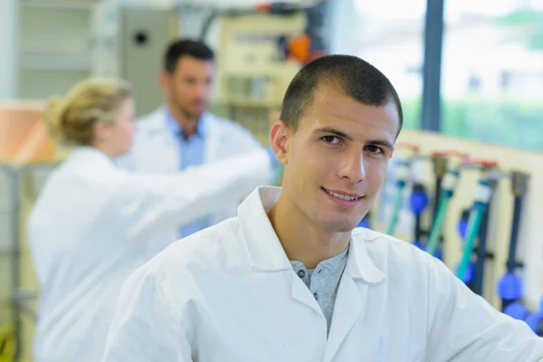 Porträtt av ung manlig tekniker klädd i labcoat — Stockfoto