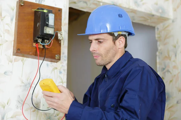 Elektricien meetspanning van stopcontact in nieuwbouw — Stockfoto