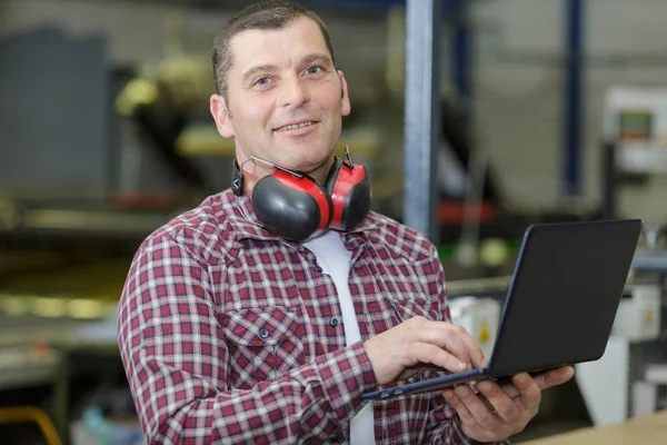 Manager mit Laptop im Lager — Stockfoto