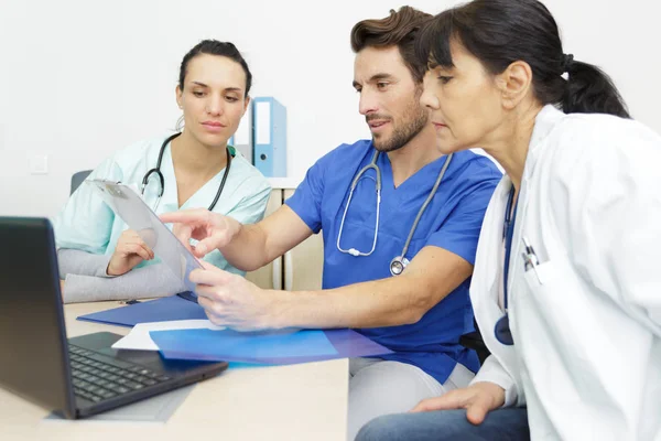 Reunião da equipe médica em torno da mesa no hospital moderno — Fotografia de Stock