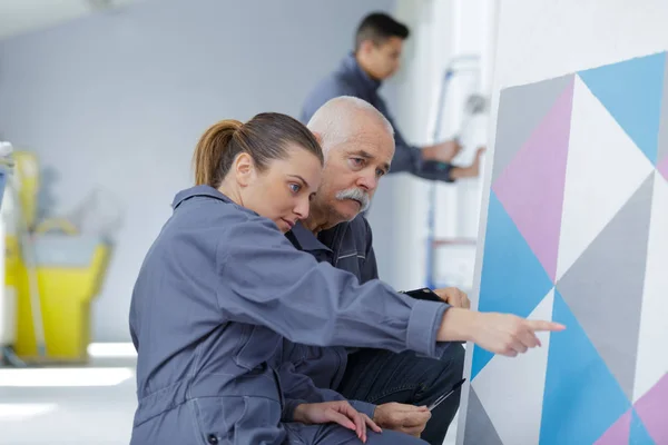 Vrouw en man schilderen een kamer — Stockfoto