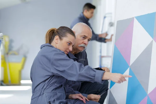 Mulher e homem pintando um quarto — Fotografia de Stock