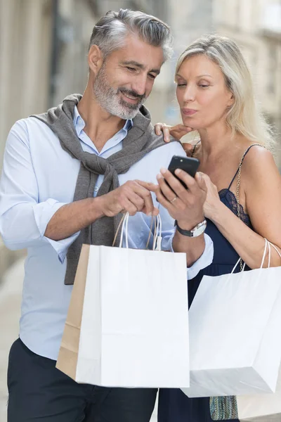 Coppia matura rilassante dopo lo shopping prendendo selfie — Foto Stock