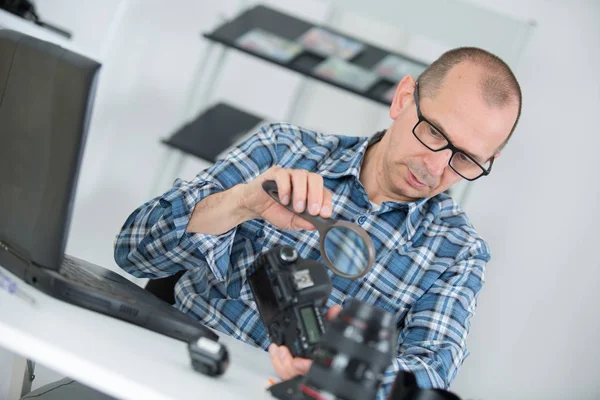 Tecnico che esamina e ripara la telecamera dslr — Foto Stock