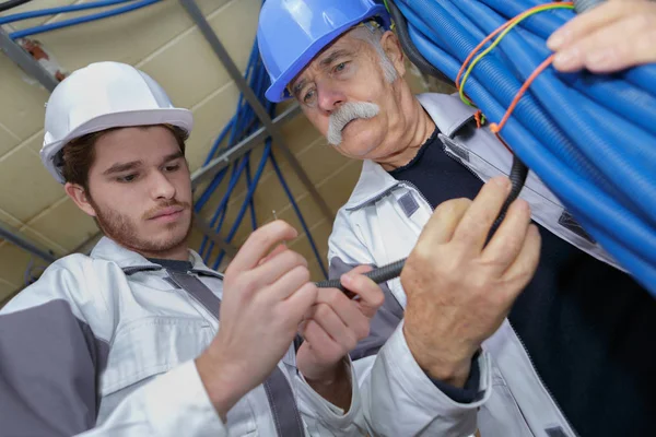 Senior craftsman and young craftswoman checking pipes — Stock Photo, Image