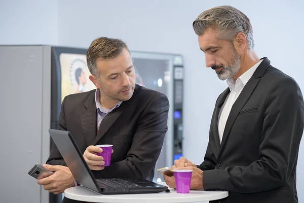 Zakenlui ontmoeten in een automaat koffiepauze — Stockfoto