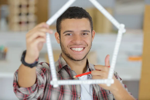 Hand met liniaal en huis op een grijze achtergrond — Stockfoto