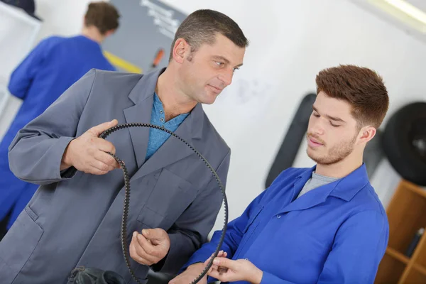 Unga mekanik lärlingar i en workshop — Stockfoto