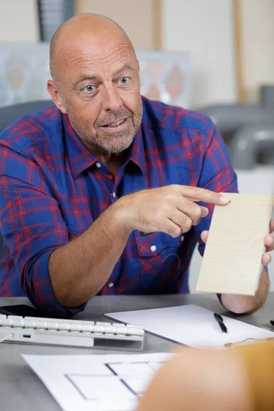 Volwassen interieur expert met voorbeeldweergave aan de klant — Stockfoto