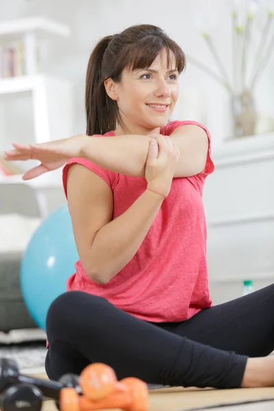 Vacker kvinna stretching armar i gymmet — Stockfoto