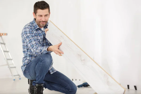 Man looking at floor board — Stock Photo, Image