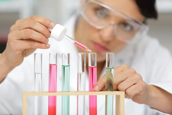 Kadın bilim adamı test tüpüne sıvı ekliyor — Stok fotoğraf
