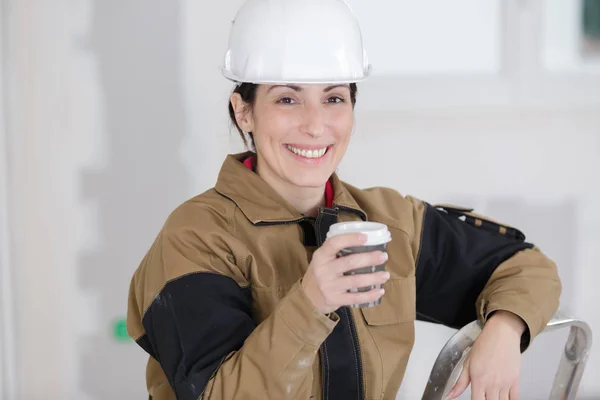 Усміхнений будівельник жінки має кавову перерву — стокове фото