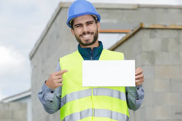 微笑的年轻工人拿着一个白色的标语牌 — 图库照片
