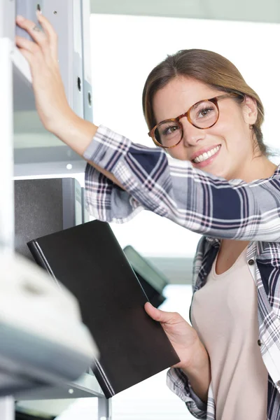 Joven secretaria trabajando y sonriendo — Foto de Stock