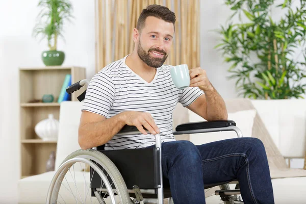 Felice uomo sulla sedia a rotelle bere caffè — Foto Stock