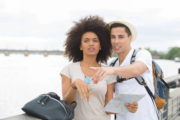 Couple on holidays pointing at something — Stock Photo, Image