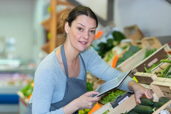 Vendedor de vegetais usando um tablet — Fotografia de Stock