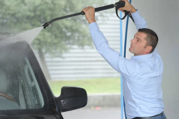 Hombre llegar a lavar el techo del vehículo con la lavadora de potencia — Foto de Stock