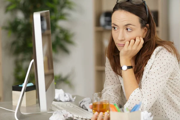 Mujer de negocios mirando el monitor de la computadora y beber whisky —  Fotos de Stock