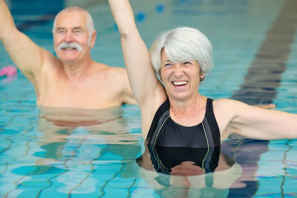 Felice coppia di anziani che balla in piscina — Foto Stock