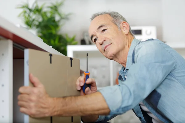 Senior man montera kök skåp — Stockfoto