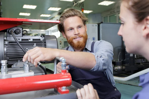 Ingenieur die machines aan vrouwelijke trainee toont — Stockfoto