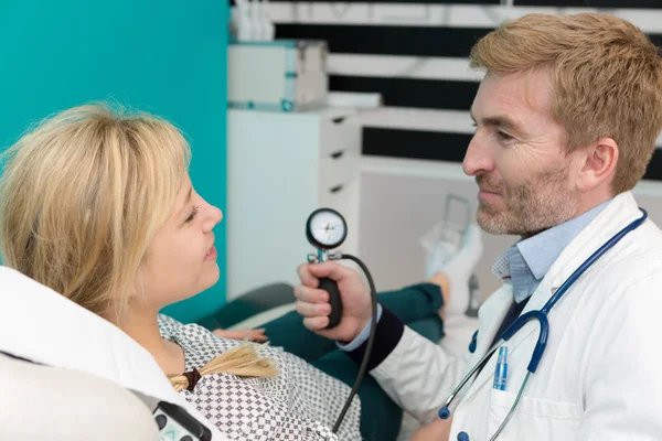 Läkaren kontrollerar blodtryck av en patient — Stockfoto