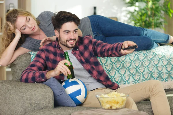 Mujer aburrida porque su hombre está viendo deporte en la televisión —  Fotos de Stock