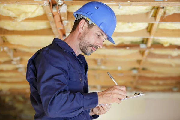 Ingegnere maschio che scrive sugli appunti nel cantiere — Foto Stock