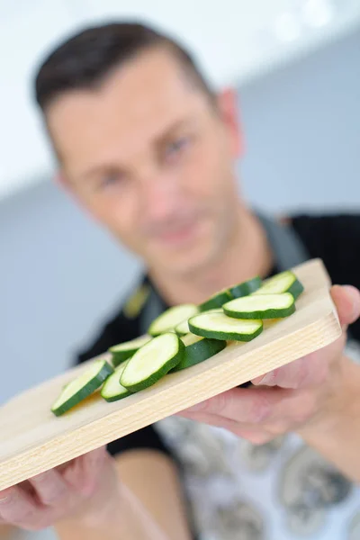Uomo che taglia verdure in cucina — Foto Stock