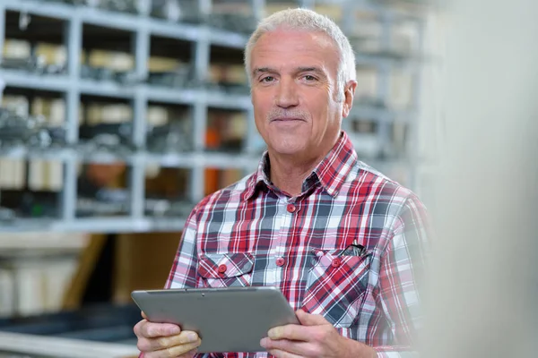 Dospělý muž držící digitální tablet ve skladu — Stock fotografie