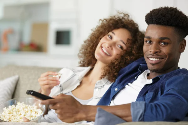 Par koppla av på soffan äta popcorn och titta på TV — Stockfoto