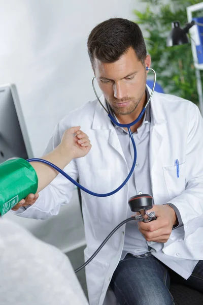 Arts meet de bloeddruk bij patiënten — Stockfoto