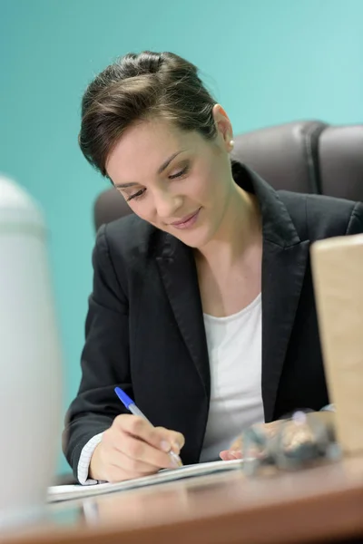Mulher atraente no escritório escrita — Fotografia de Stock