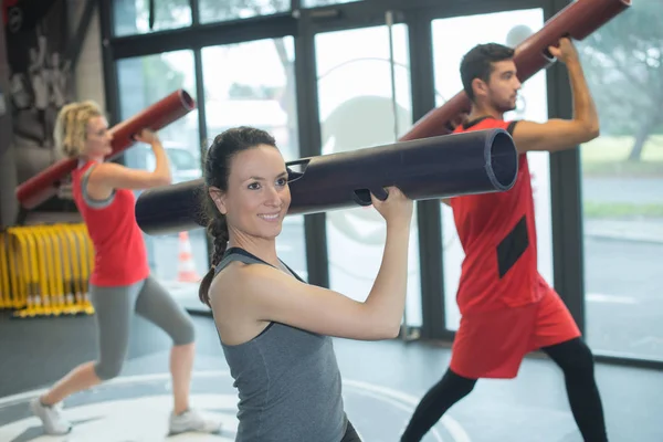 Classe de exercício trabalhando fora usando acessório cilíndrico — Fotografia de Stock