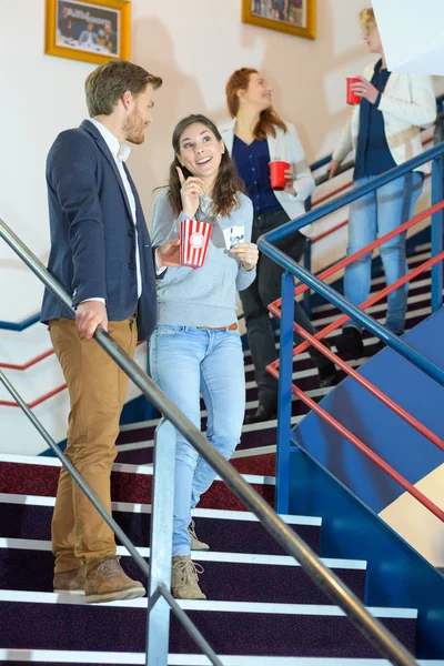Couple walking down the stairs in cinema building — Stock Photo, Image