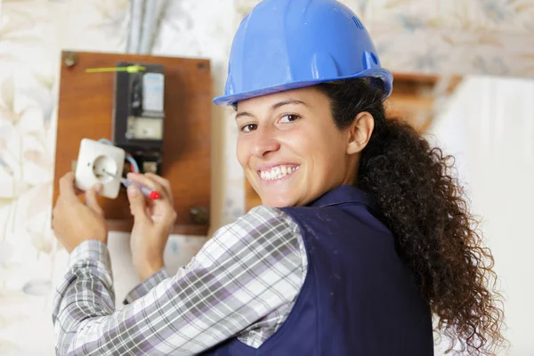 Eletricista fêmea inspeciona disjuntor do sistema elétrico — Fotografia de Stock