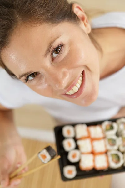 Glückliche Frau isst Sushi — Stockfoto