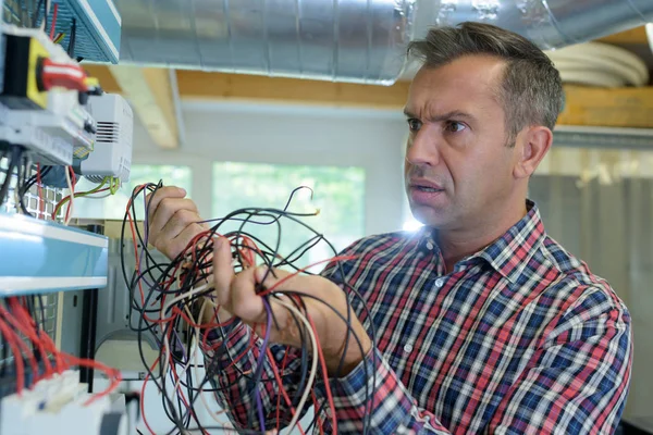 Werknemer geschokt om elektrische puinhoop te vinden — Stockfoto