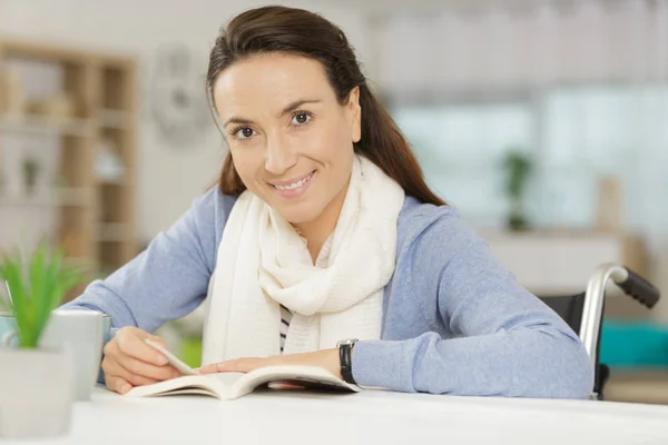 Mujer sentada en una silla de ruedas concepto de discapacidad lectura libro —  Fotos de Stock