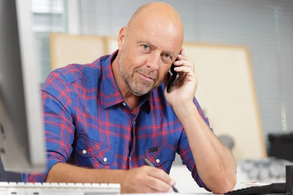 Confident man in office on phone — Stock Photo, Image