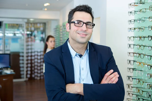 Vertrouwen man met armen gekruist in een opticien — Stockfoto