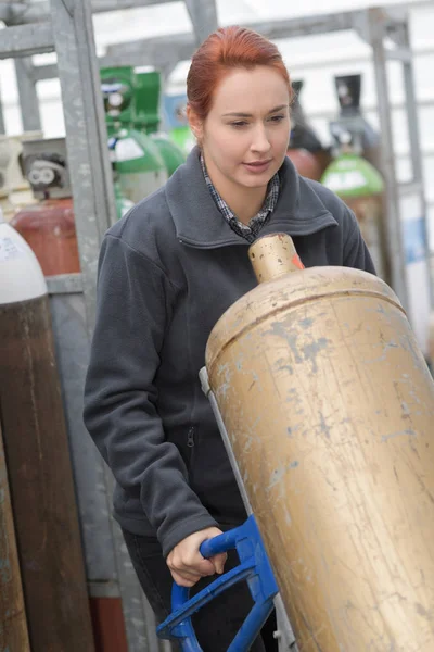 Woman working with tanks for compressed air — Stock Photo, Image